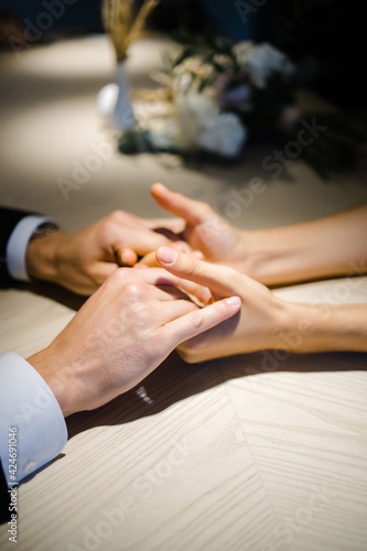 male and female hands hold each other while sitting at the table