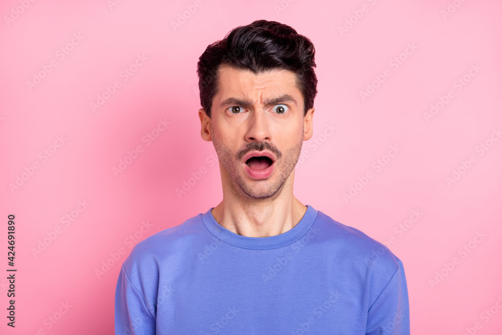 Photo of brunet impressed guy open mouth wear blue shirt isolated on pastel pink color background Photo of brunet impressed guy open mouth wear blue shirt isolated on pastel pink color background