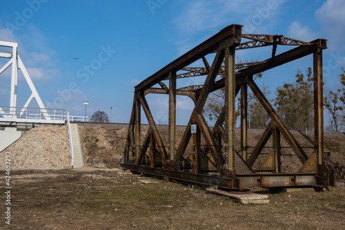 Rusty spans of the old railway bridge have been dismantled. Perspective photo taken on a sunny day.