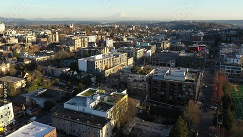 Cinematic night aerial drone rise reveal shot of Mt. Rainier with Capitol Hill, Pike - Pine, First Hill, Central Seattle, downtown, skyscrapers at sunset in King County, Washington photo