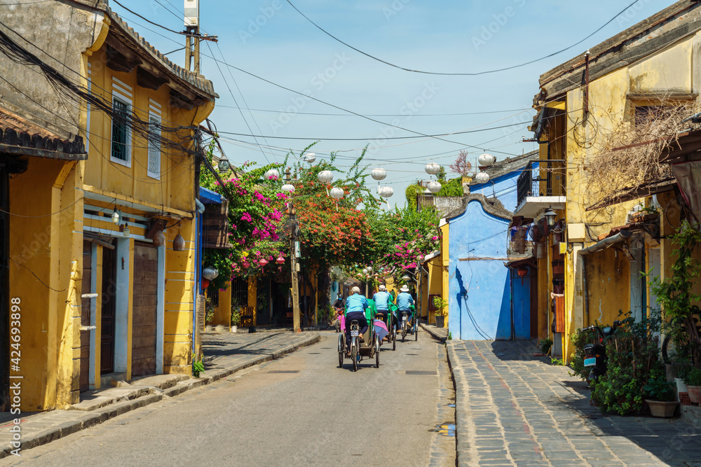 Street view of Hoi An ancient town, central Vietnam, with cyclo moving on street