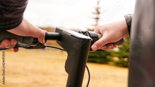 Close-up of male hand pressing speed button on electric scooter