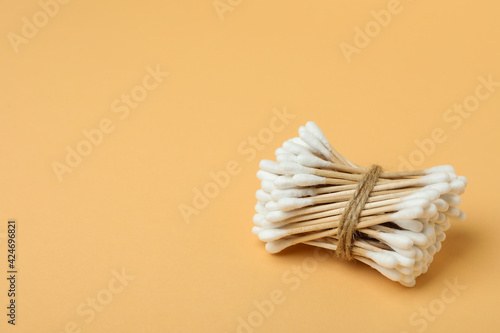 Cotton swabs on beige background  space for text