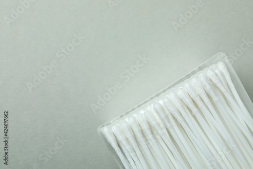 Plastic box with cotton swabs on light gray background