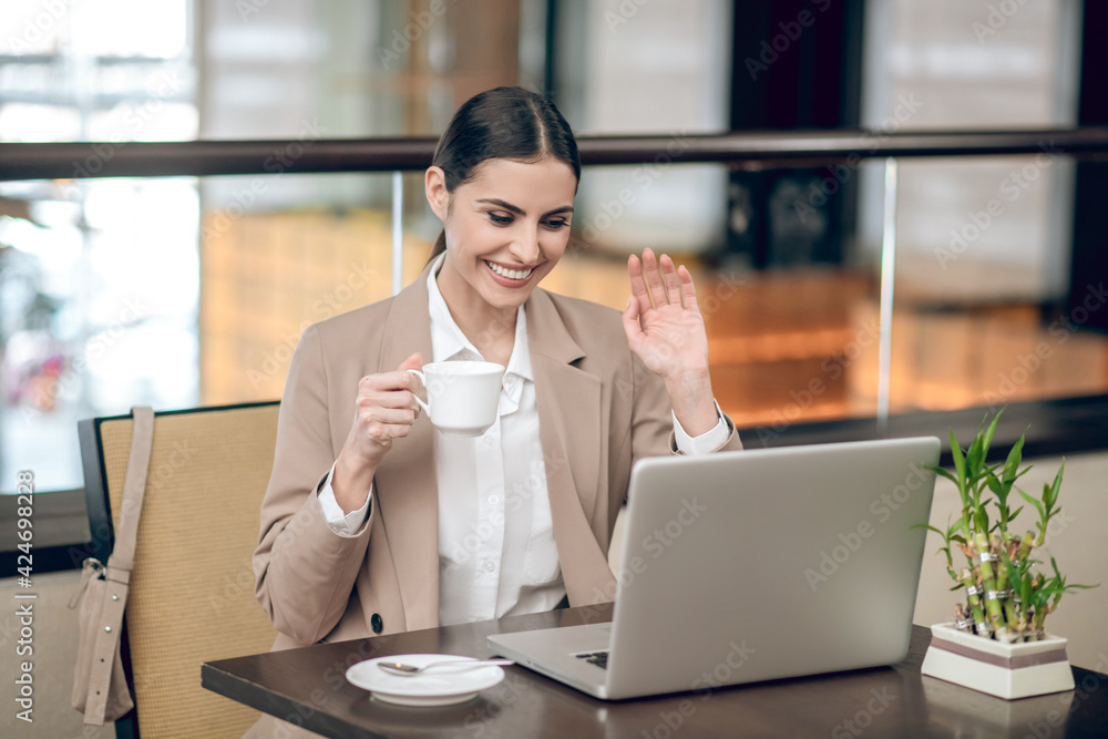 Beautiful young businesswoman having coofee and checking her mail Beautiful young businesswoman having coofee and checking her mail