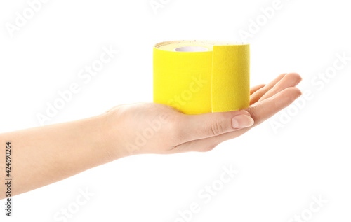Woman with bright kinesio tape in roll on white background, closeup