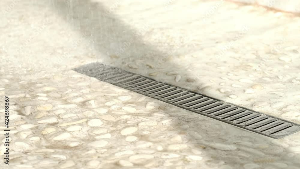 Floor drain, running water in shower. slow motion of tiled floor in a