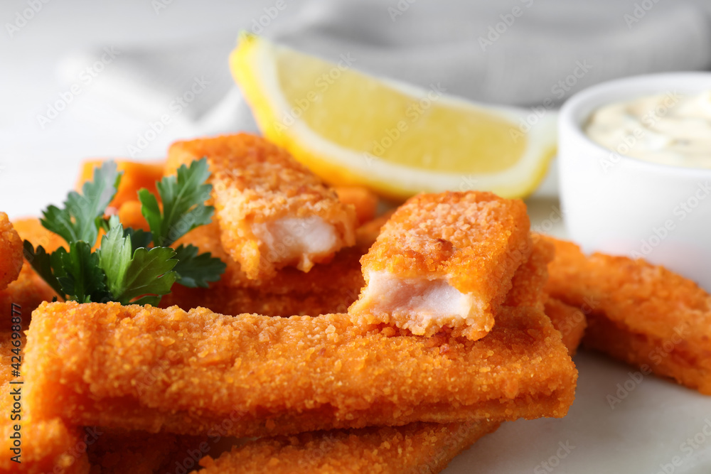 Tasty fresh fish fingers on white board, closeup Tasty fresh fish fingers on white board, closeup