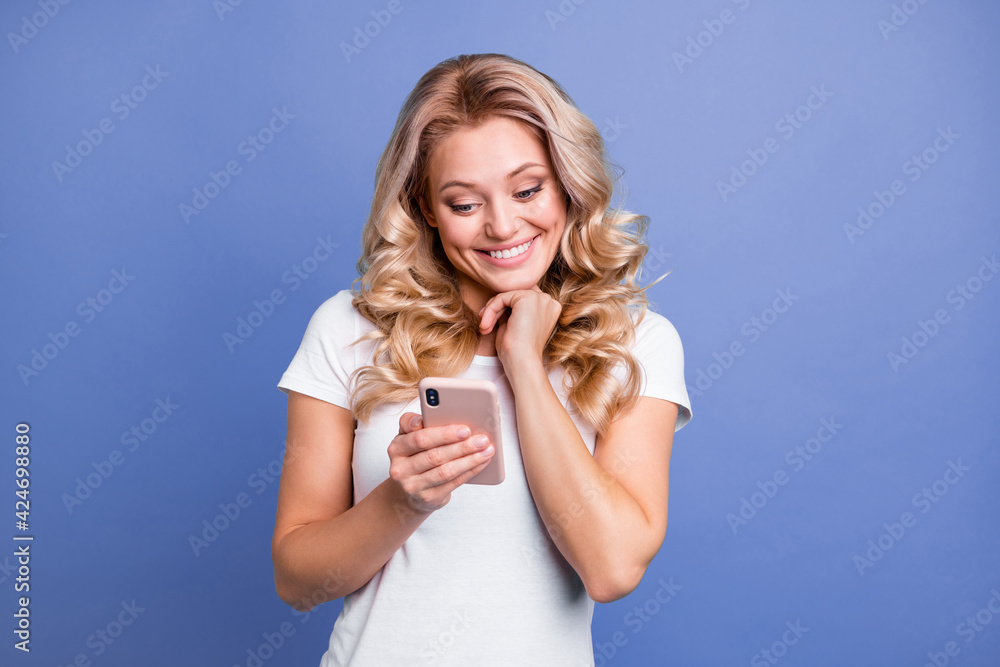 Portrait of attractive cheerful wavy-haired woman using device chatting having fun isolated over blue pastel color background Portrait of attractive cheerful wavy-haired woman using device chatting having fun isolated over blue pastel color background