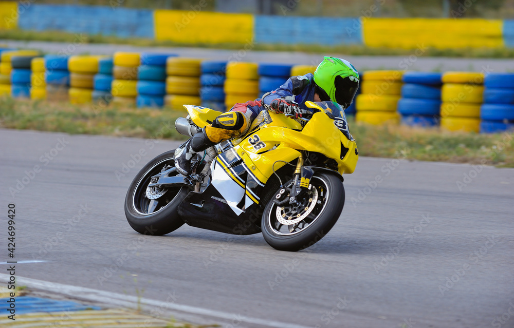Motorcycle practice leaning into a fast corner on track Motorcycle practice leaning into a fast corner on track