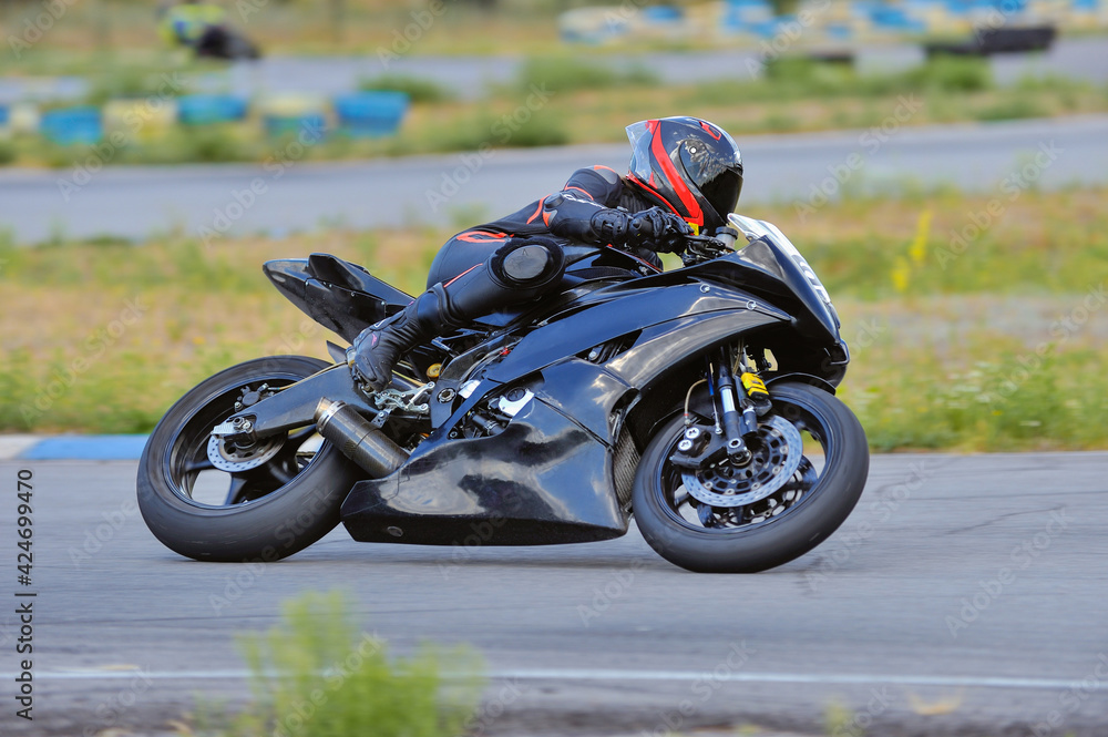 Motorcycle practice leaning into a fast corner on track Motorcycle practice leaning into a fast corner on track
