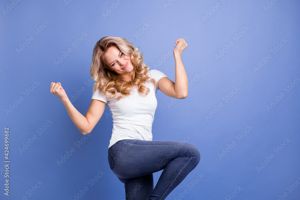 Portrait of attractive cheerful wavy-haired woman dancing celebrating good luck isolated over blue pastel color background Portrait of attractive cheerful wavy-haired woman dancing celebrating good luck isolated over blue pastel color background