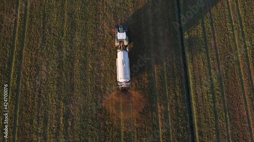 tractor with slurry tanker at work in the plowed field photo