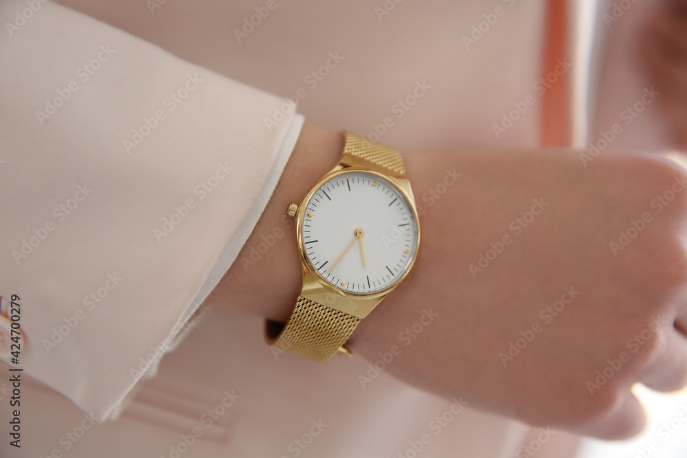 Woman in pink jacket with luxury wristwatch, closeup Woman in pink jacket with luxury wristwatch, closeup