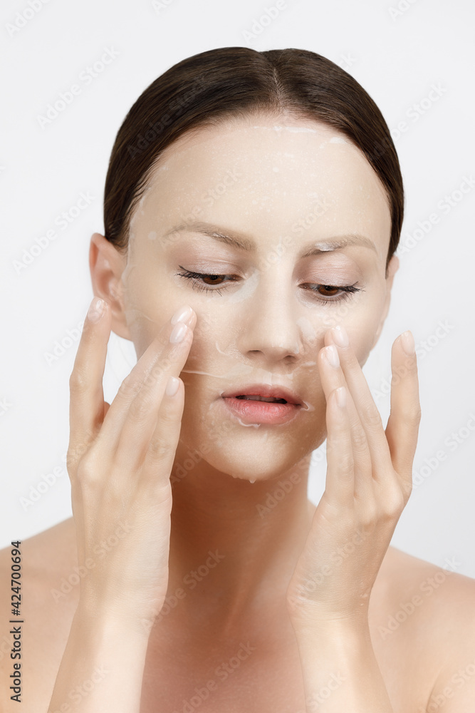 Face Skin Care moisturizing Korean cosmetics concept. Portrait Of Beautiful woman applying and smoothing White Sheet Mask Face Skin Care moisturizing Korean cosmetics concept. Portrait Of Beautiful woman applying and smoothing White Sheet Mask
