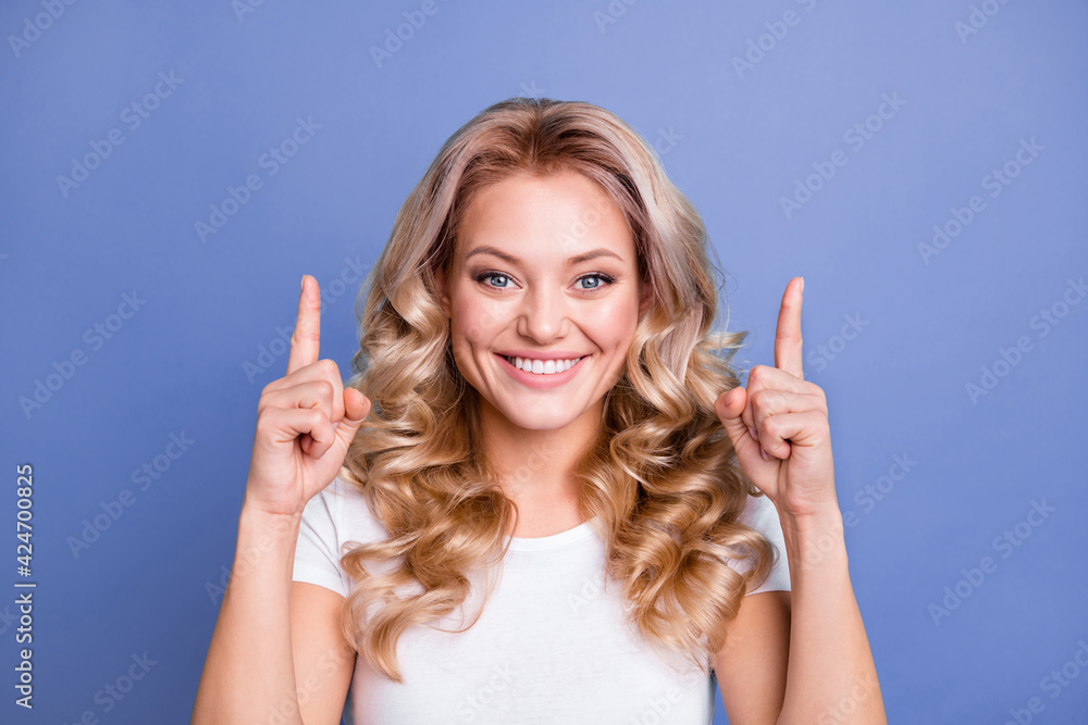 Photo of young happy good mood positive smiling girl point finger copyspace advertisement isolated on blue color background Photo of young happy good mood positive smiling girl point finger copyspace advertisement isolated on blue color background