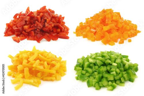 Red, orange, yellow and green brunoise cut blocks of bell pepper on a white background