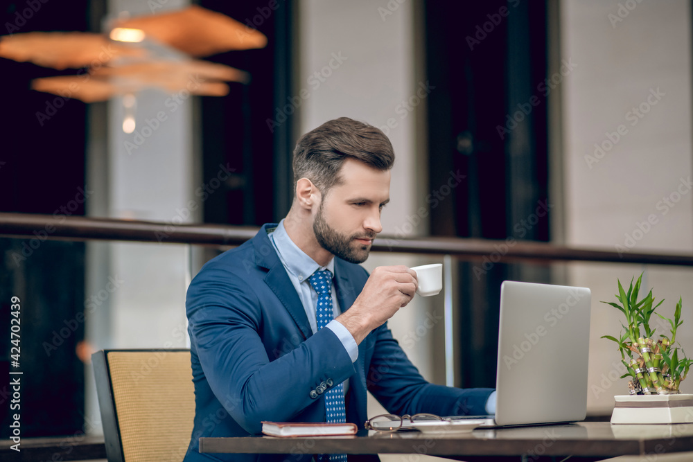 Young businessman in a nice suit working in the office and looking concentrated Young businessman in a nice suit working in the office and looking concentrated