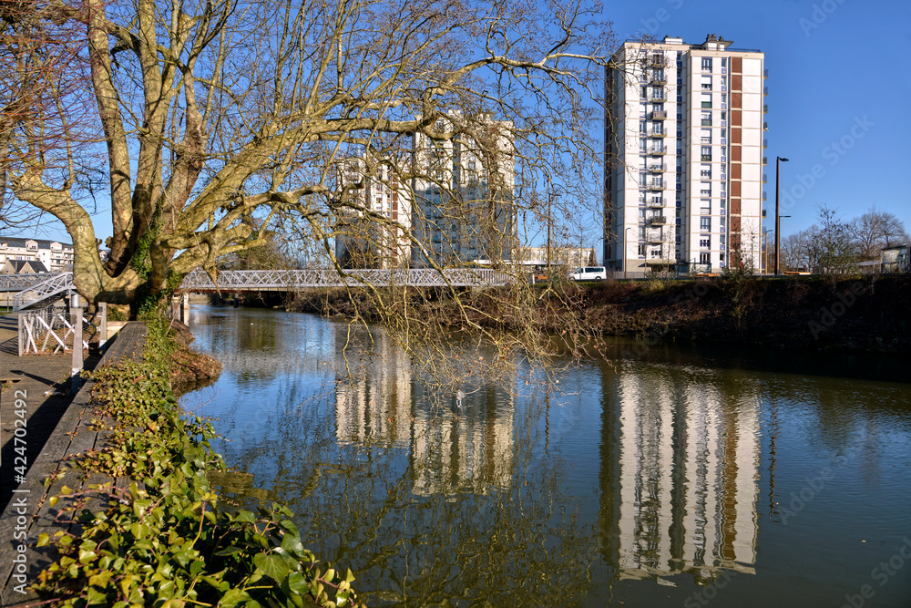 Trees and apartment blocks on the bank of river Sarthe at Alençon of the Lower Normandy region in France