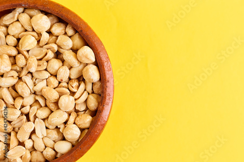 Nuts bowl on yellow background. Healthy vegan food.