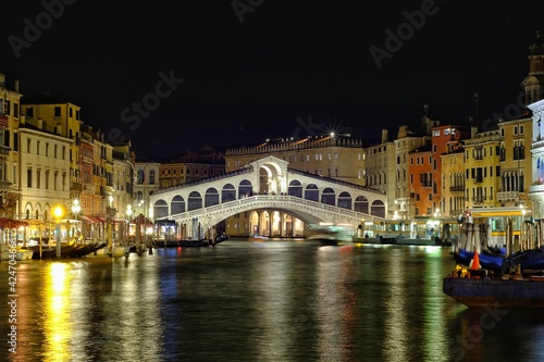 : View of the famous Rialto bridge by night in Venice Italy