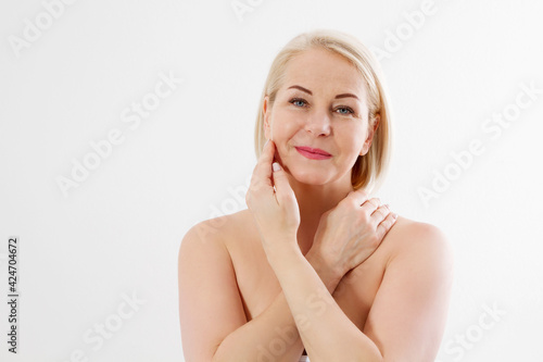 Beauty middle age woman face portrait. Spa and anti aging concept Isolated on white background. Plastic surgery and collagen face injections. Wrinkles and menopause. Mock up. Copy space