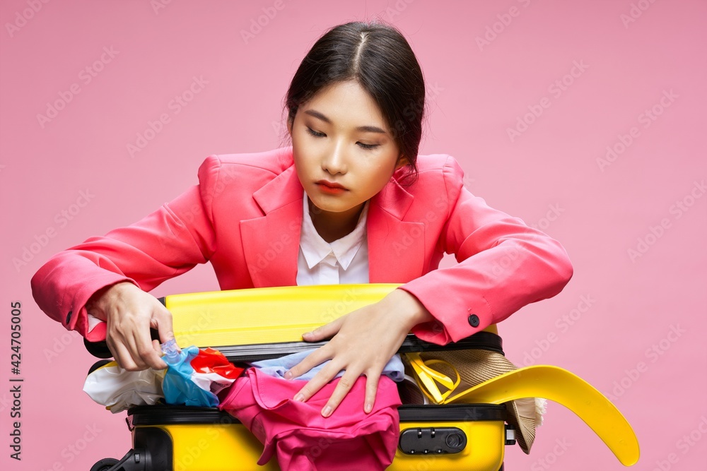 traveler with unbuttoned suitcase and multicolored clothes pink background traveler with unbuttoned suitcase and multicolored clothes pink background