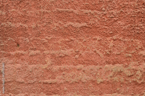 Red-orange painted wall with cinder block texture. Abstract interior background.