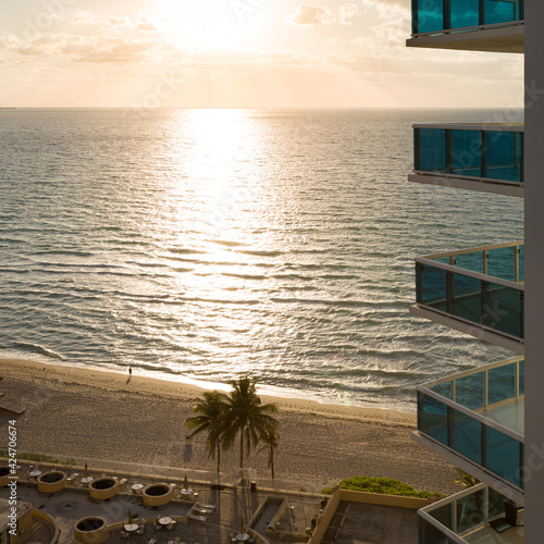 Beautiful view of the ocean beach from the balcony in the early morning. Tropical landscape. Clean, golden sand on the shores of the Atlantic Ocean, clear azure sea, tropical sun.