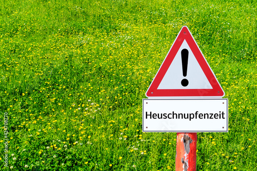 Warnschild Heuschnupfen mit einer Wiese als Hintergrund photo