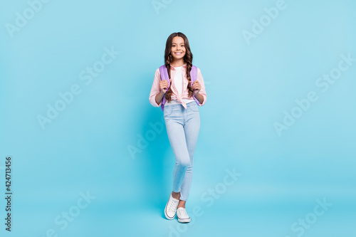 Full sized photo of young lovely pretty smiling positive schoolgirl wear backpack isolated on blue color background