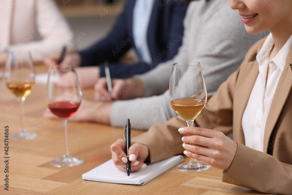Sommeliers tasting different sorts of wine at table indoors, closeup Sommeliers tasting different sorts of wine at table indoors, closeup
