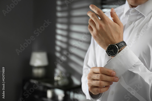 Man with luxury wrist watch indoors, closeup. Space for text