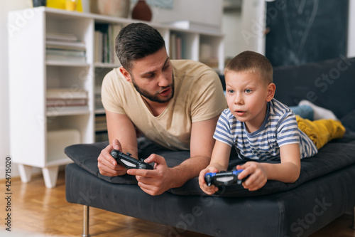 father and son playing video games at home