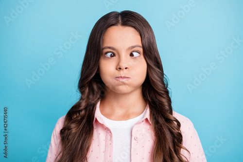 Photo of funny wavy hairdo girl fooling around eyes hold breath wear dotted isolated on blue color background