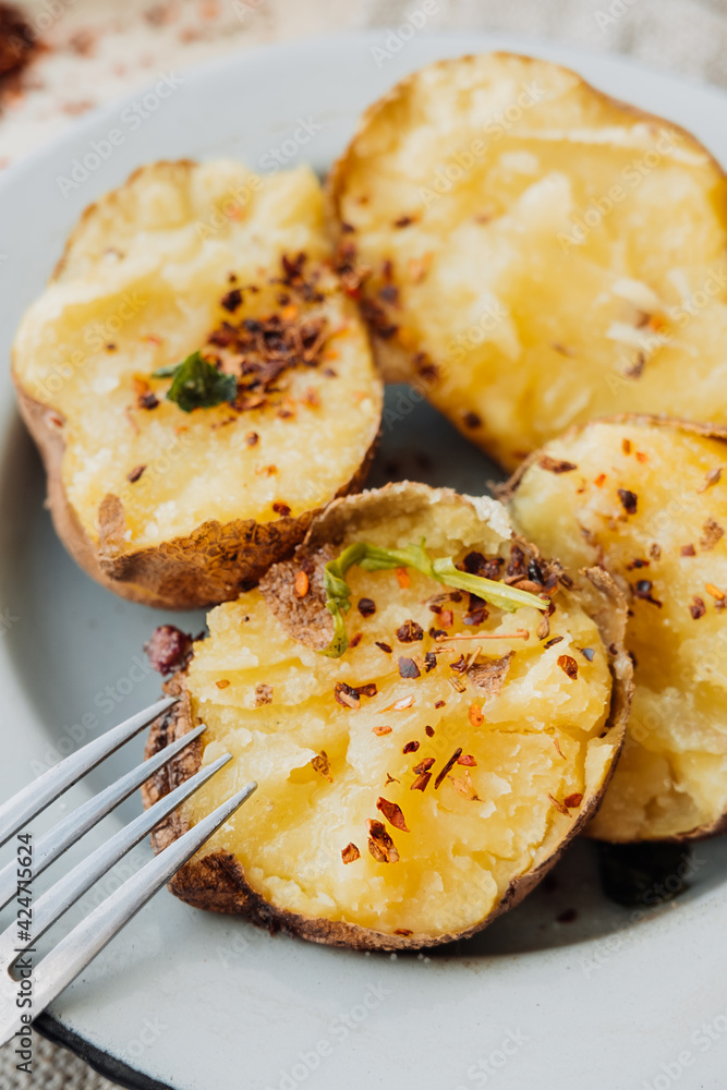baked whole potatoes in the skin with olive oil, coarse salt, red pepper and paprika. quick potato recipes. country food. food blog. selective focus