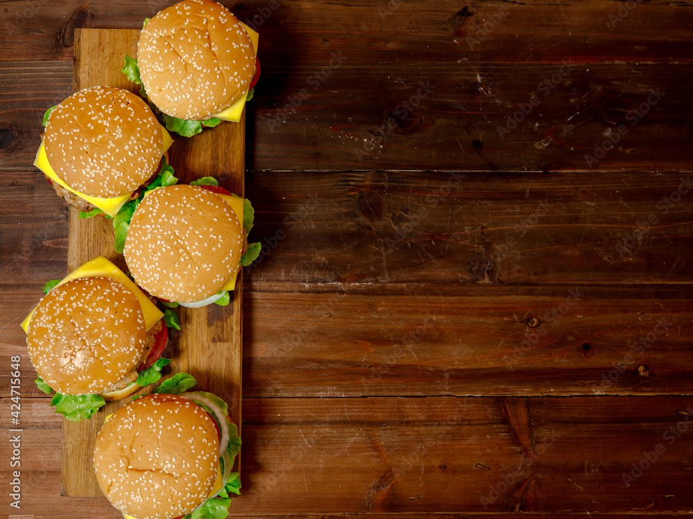 Set of pork burgers on wooden plate taken from top view