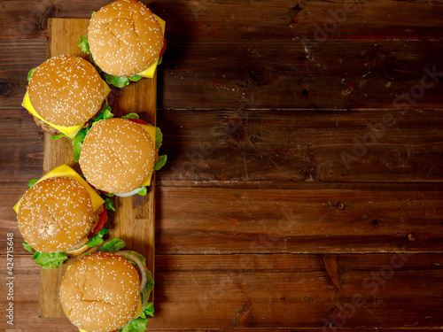 Set of pork burgers on wooden plate taken from top view