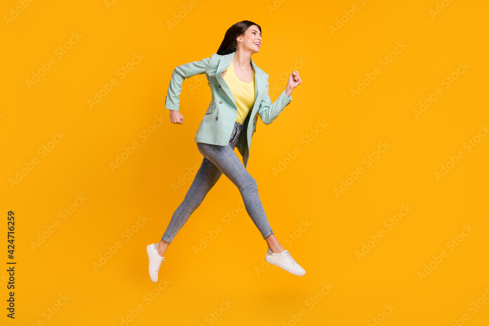 Full size profile side photo of young attractive lovely pretty cheerful girl running fast isolated on yellow color background