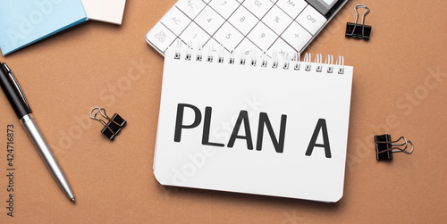 PLAN A on notepad with pen, glasses and calculator