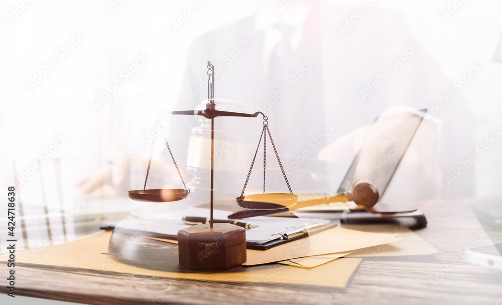 Business and lawyers discussing contract papers with brass scale on desk in office. Law, legal services, advice, justice and law concept picture with film grain effect Business and lawyers discussing contract papers with brass scale on desk in office. Law, legal services, advice, justice and law concept picture with film grain effect