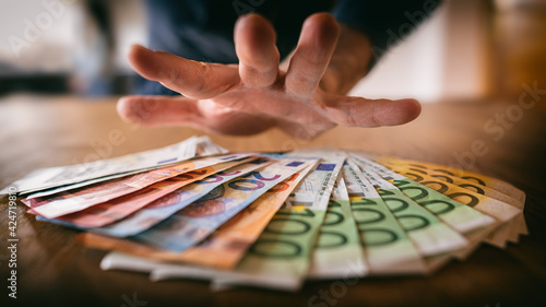 Fotografiet Hand greift nach Euro-Banknoten