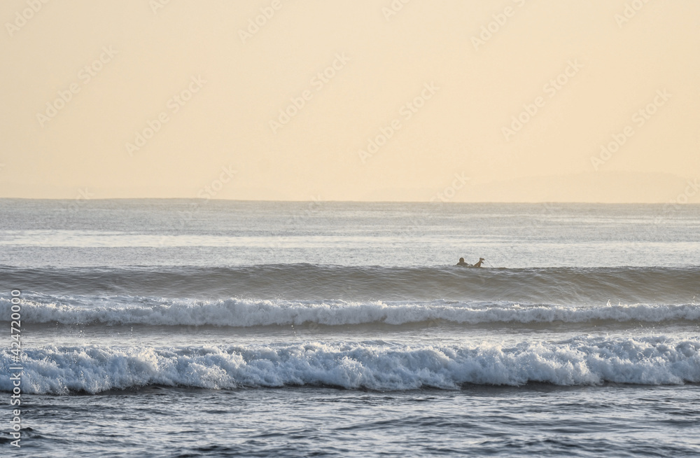 surfing on the beach in Bali at sunrise, dawn patrol