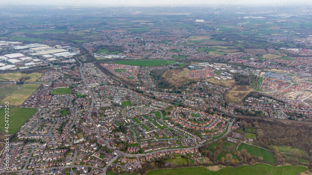 Aerial drone photo of a typical residential housing estate in England showing a very high view of the village of Wakefield in West Yorkshire in the UK taken in the spring time