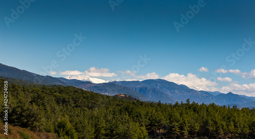 Hills with forest and mountain range on horizon. © Sergey Fedoskin