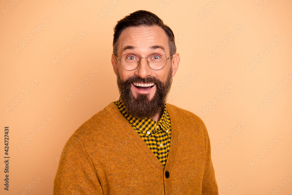 Portrait of nice brunet hairdo optimistic man wear spectacles brown cardigan isolated on pastel beige color background Portrait of nice brunet hairdo optimistic man wear spectacles brown cardigan isolated on pastel beige color background