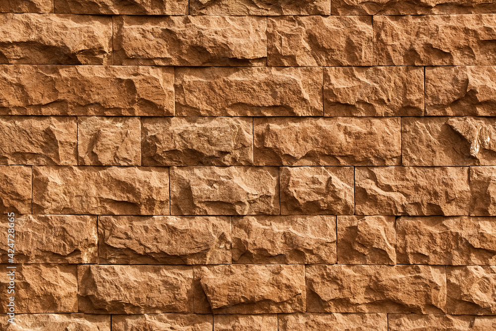 Sand-colored stone wall background texture. Sand-colored stone wall background texture.