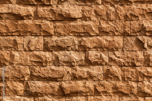 Sand-colored stone wall background texture.