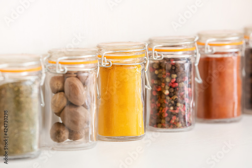 Jars with different spices on light background, closeup
