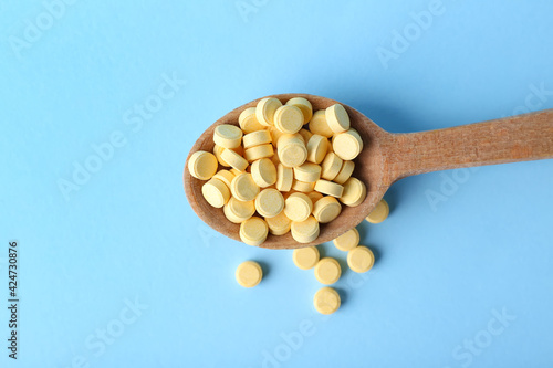 Tableau sur toile Spoon with folic acid pills on color background